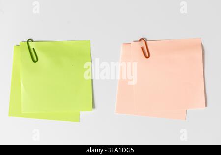 Green and orange blank sticky notes with paper clips isolated on white background. template mockup Stock Photo