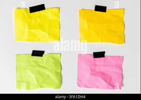four blank colorful crumpled sticky note papers with black adhesive tape isolated on white background. Template mockup Stock Photo