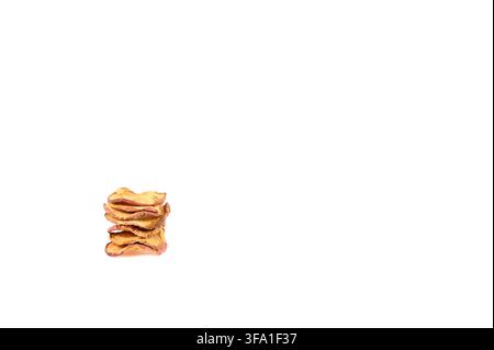 Neatly stacked small pile of dried red apple slices on white ground Stock Photo