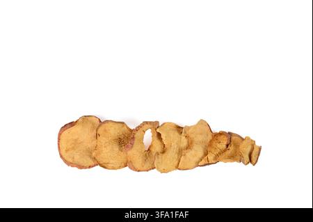 Row of sliced dried or dehydrated red apples overlapping and decreasing in size on white background Stock Photo