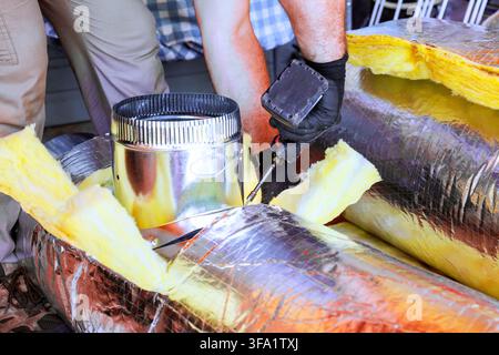 Worker are installing ductwork while repairing HVAC ventilation system inside building. Stock Photo