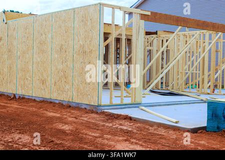 Builders are working on placing wooden beams frames for structure on site with some materials around. Stock Photo