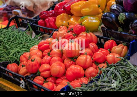 Fresh local cuor di bue oxheart tomatoes and green beans in boxes on display at a farmers market stall in Sanremo, Italy Stock Photo