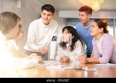 Group of students sitting in circle studying together in study hall of university Stock Photo