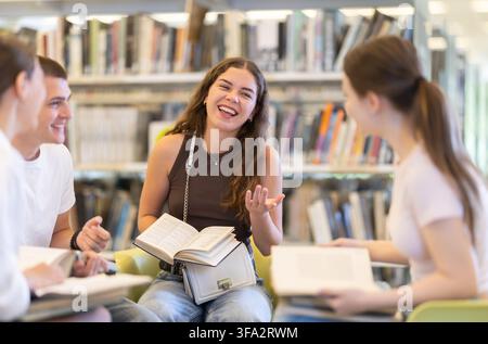 Group of students reading and discussing books in library Stock Photo