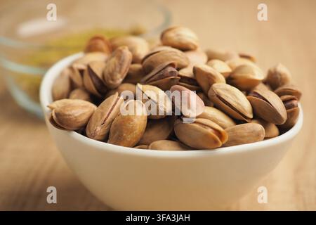 Bowl of pistachio nuts on a wooden table Stock Photo