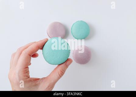 Top view of four turquoise and pink French macarons on white background, flat lay sweet dessert composition. High quality photo Stock Photo