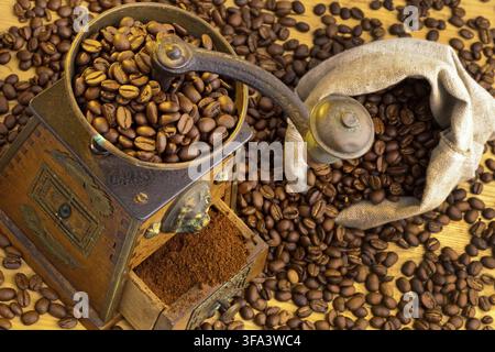 Many coffee beans lie next to a coffee grinder. Freshly ground coffee, Austria Stock Photo