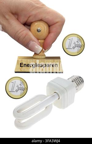 Saving money with an energy-saving lamp, hand with stamp, studio photo, Federal Republic of Germany Stock Photo