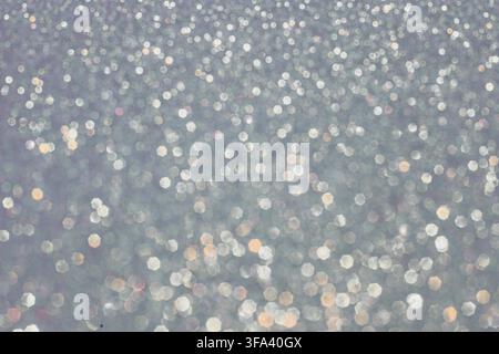 Abstract glitter lights textured silver, gray and white colored background, de-focused, bokeh. Christmas or New Year festive blured sparkling backgrou Stock Photo