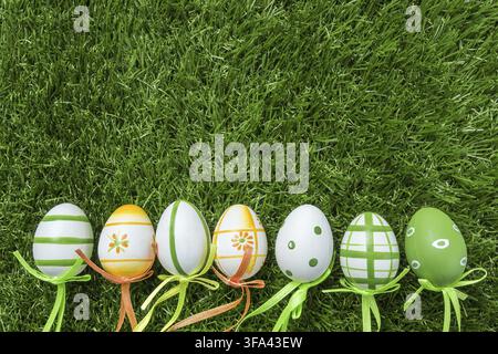 A row of five colorful easter eggs on green grass in Springtime Stock Photo