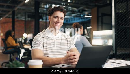 Happy, laptop and portrait of businessman in office with confidence for career in web development. Computer, about us and software developer with Stock Photo