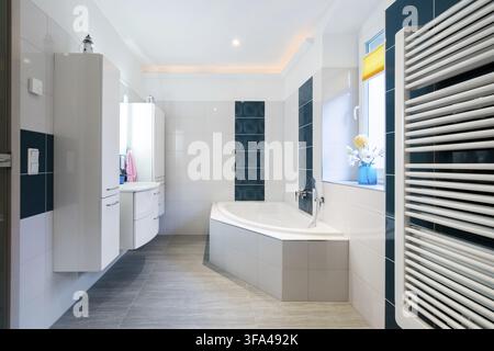 Modern Bathroom - Glossy white and blue tiles - bathtub, sink and floor heating horizontal shot Stock Photo