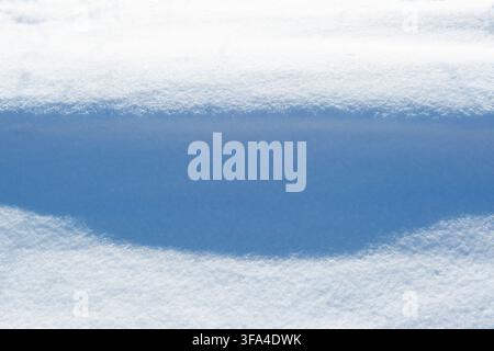 a Light and shadow, a pattern on the surface of the snow. Play of light, a beautiful winter background. Stock Photo