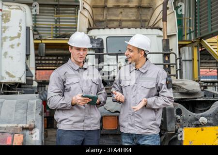 Two logistics workers engaging in a discussion about operations at a warehouse facility. Perfect for illustrating teamwork, warehouse management, and Stock Photo