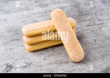 Savoiardi biscuits stacked on gray background with one leaning biscuit Stock Photo