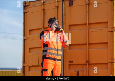 Construction worker wearing a gas mask and safety jacket during an outdoor inspection for hazardous materials. Ideal for safety, construction, and occ Stock Photo