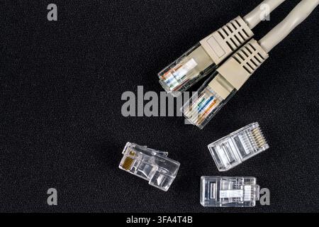 Network cable with connectors. Close-up connectors on a black background. Stock Photo
