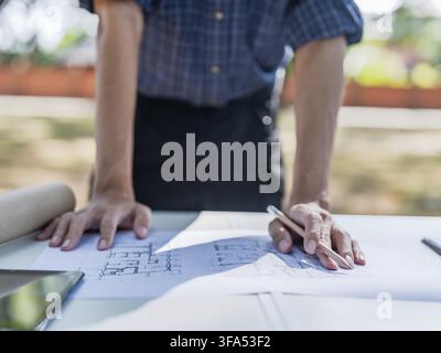 Asian construction engineer working at outdoor construction site managing building project at site for infrastructure development Stock Photo