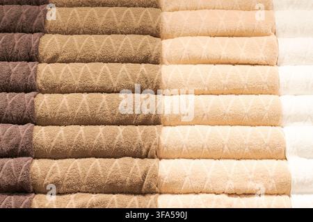 Stacked terry cotton towels in neutral earthy tones with a diamond texture pattern, ideal for home textile, tactile detail and bathroom content Stock Photo