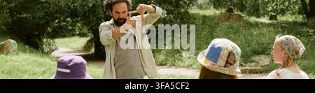 Header of Middle Aged Man Teaching Art Class to Students Outdoors Stock Photo