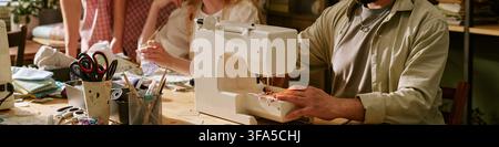 Header of Man Using Sewing Machine in Creative Fashion Workshop Stock Photo