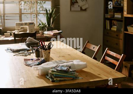 Empty Creative Sewing Workshop with Tools on Wooden Table Stock Photo