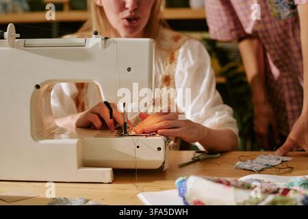 Woman Using Sewing Machine during Creative Workshop Class Stock Photo