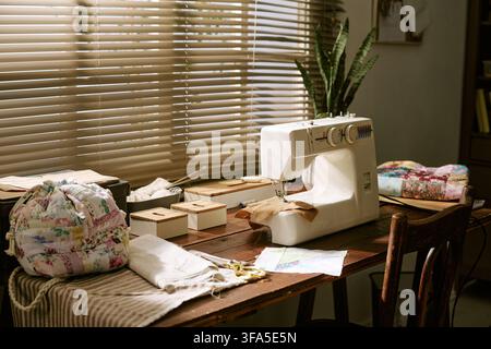 Sewing Machine on Wooden Table in Creative Craft Workshop Stock Photo