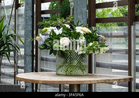 Bouquet of flowers in a vase on a wooden table Stock Photo