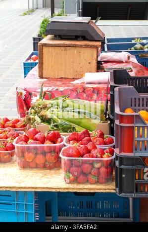 Strawberries in plastic boxes for sale on a market stall. Stock Photo