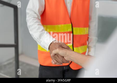 Engineer team hands shaking greeting start up plan new project contract in office center at construction site, industry ,architecture, partner, teamwo Stock Photo