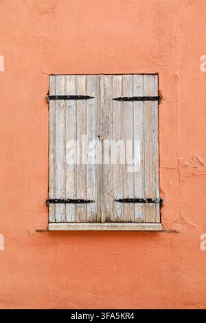 Vintage wooden window on a weathered plaster wall of an historic house Stock Photo