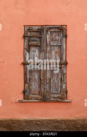 Vintage wooden window on a weathered plaster wall of an historic house Stock Photo
