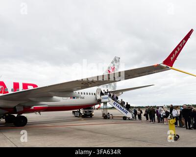 Manchester, UK - June 05, 2026: Passengers queue to board a commercial airplane on the tarmac, capturing travel and departure atmosphere. Stock Photo