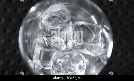 Ice cubes chilling a drink inside a glass, creating a refreshing, cold beverage. Abstract background pattern Stock Photo