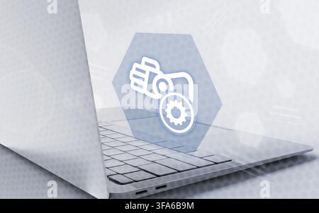 A robotic arm icon hovers above a modern laptop, symbolizing advanced industrial automation, digital engineering, and innovative smart technology. Stock Photo