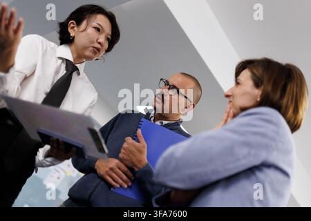 Business meeting with diverse professionals discussing strategies in a modern office setting during the afternoon Stock Photo
