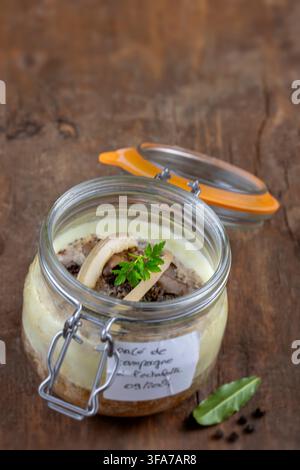 A beautifully layered dessert with cookie crumbles, chocolate, and fresh herbs is presented in a glass jar. Stock Photo