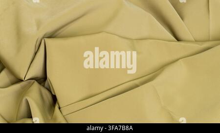Smooth olive green fabric texture with elegant folds and soft lighting creating deep shadows and bright highlights. The continuous textile surface sho Stock Photo