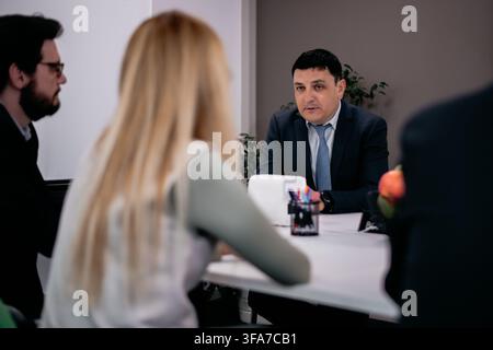 Group discussion taking place in a professional setting with a serious business atmosphere Stock Photo