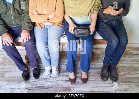 Multi generational group of people waiting, healthcare consultation and patient waiting room concept, diverse family support. Individuals sitting on a Stock Photo