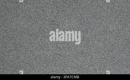 Horizontal close up of a polished gray granite surface with black specks, a salt‑and‑pepper look, and smooth shiny stone texture Stock Photo