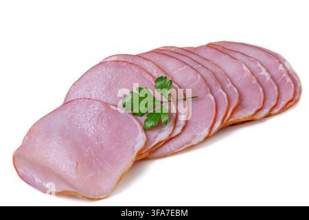 Slices of pink ham are arranged in an overlapping row on a white background. A single green parsley leaf rests on top of the meat. bacon Bsip 016952 046 Stock Photo