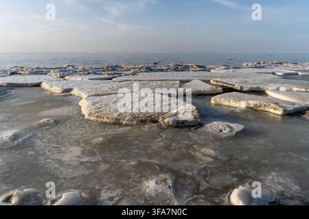 Drifting sea ice and broken ice floes on a partially frozen coastal sea Stock Photo
