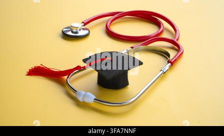 Graduation Cap Inside Red Medical Stethoscope for Medical Education Cost and Healthcare Degree Concept Stock Photo