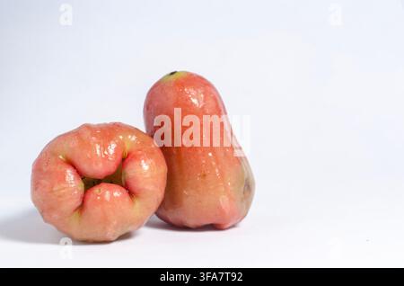 Two Wet Rose Apples in a Small Woven Basket on a White Background Stock Photo