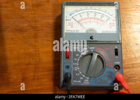 Vintage Analog Multimeter Measuring Tool on Wooden Table in Electronics Workshop Stock Photo