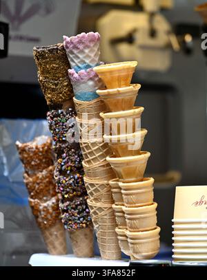 Stacks of empty ice cream cones, some with chocolate or nut coatings Stock Photo