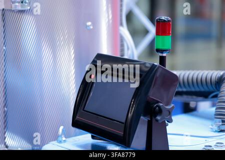 Industrial HMI touchscreen control console and red green signal tower light. Selective focus. Stock Photo